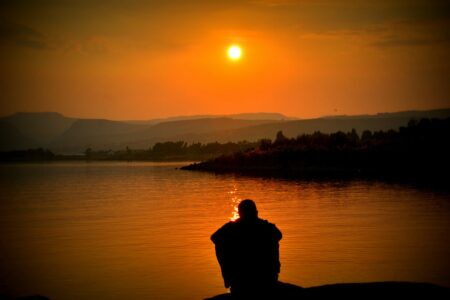 Man watching sunset over lake